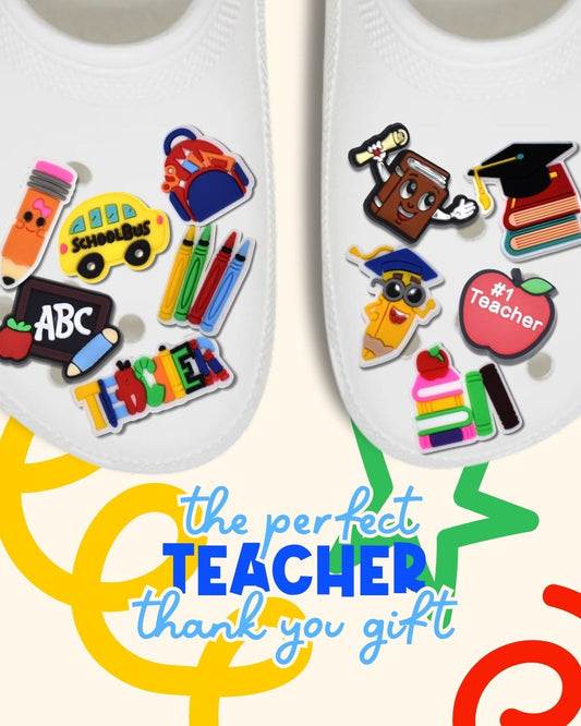 White Crocs decorated with teacher-themed charms including school bus, crayons, ABC chalkboard, pencil, apple and graduation cap designs - perfect teacher thank you gift